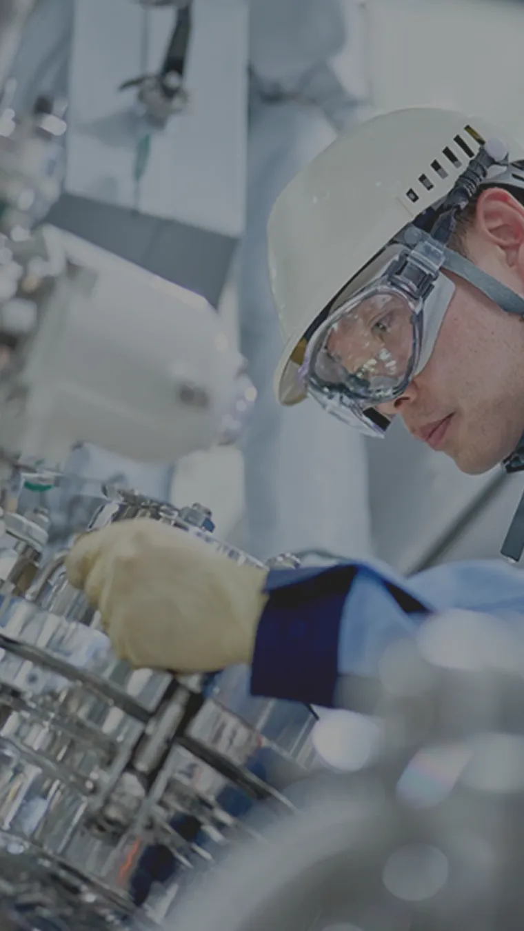 製造工場の設備を操作する男性の写真